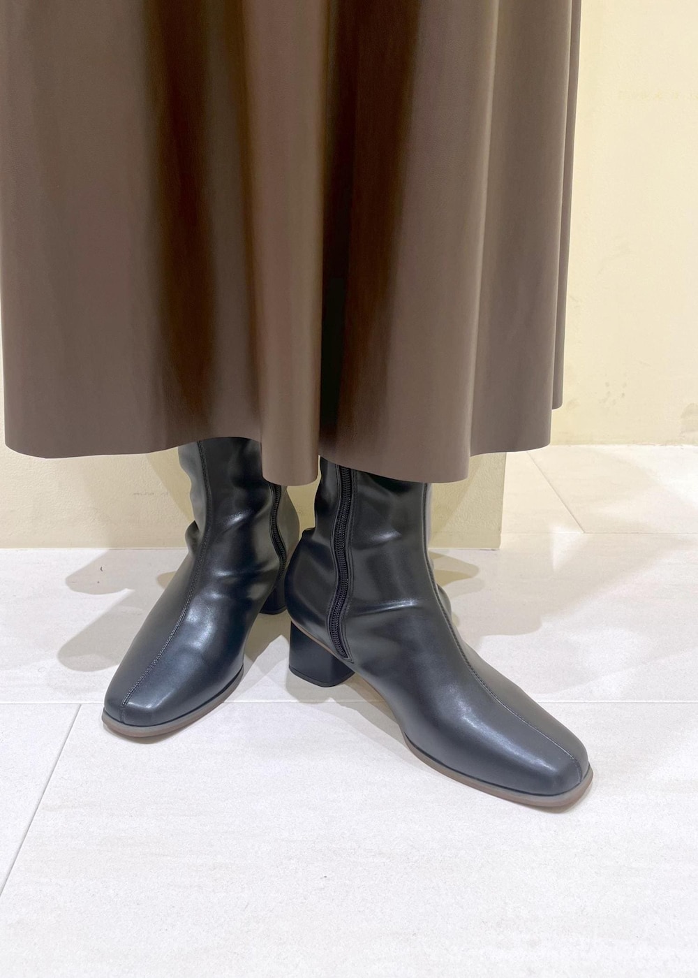 ブラック系のシャツ/ブラウス、グリーン系のスカート、ブラック系のブーツを着用したレディースの秋コーディネートの10枚目の写真