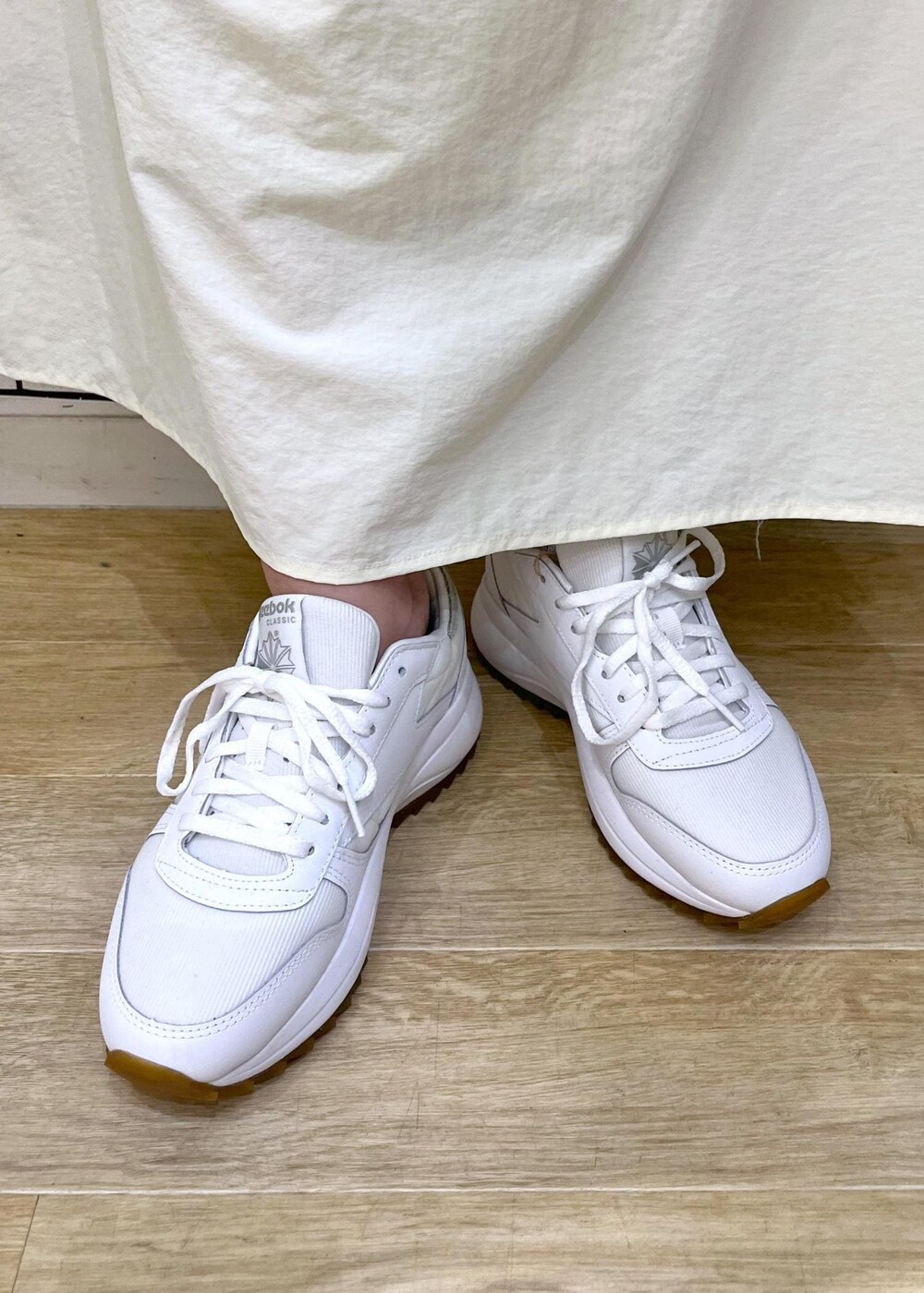 ホワイト系のスニーカー、グレー系のショルダーバッグ、ホワイト系のスカートを着用したレディースの夏コーディネートの10枚目の写真