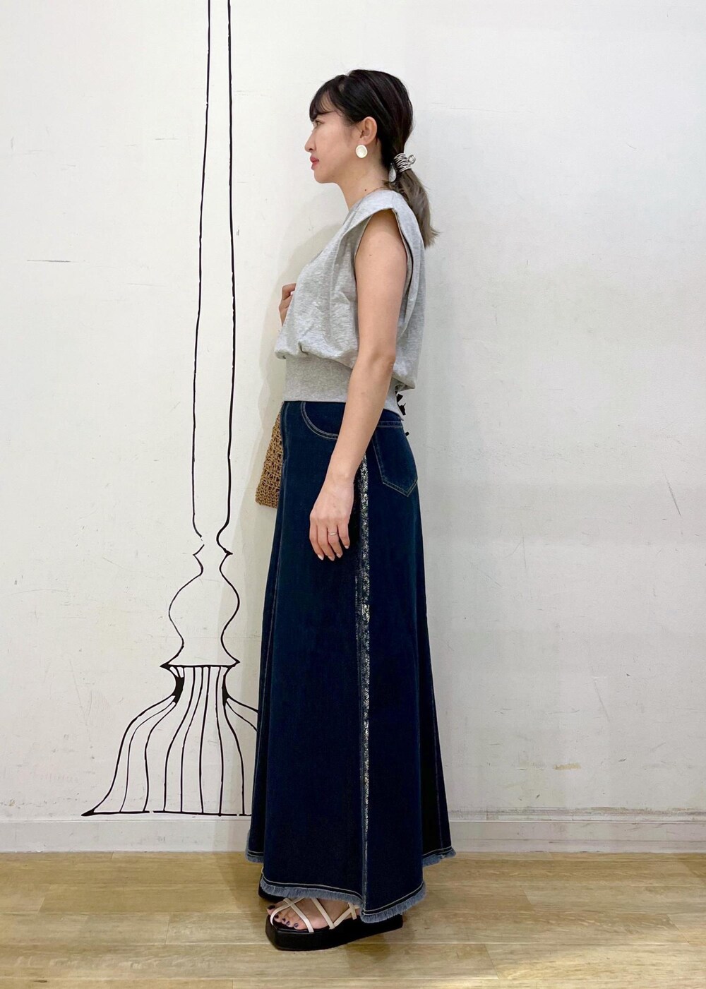 ホワイト系のサンダル、ブラック系のトートバッグ、グレー系のスウェットを着用したレディースの夏コーディネートの2枚目の写真