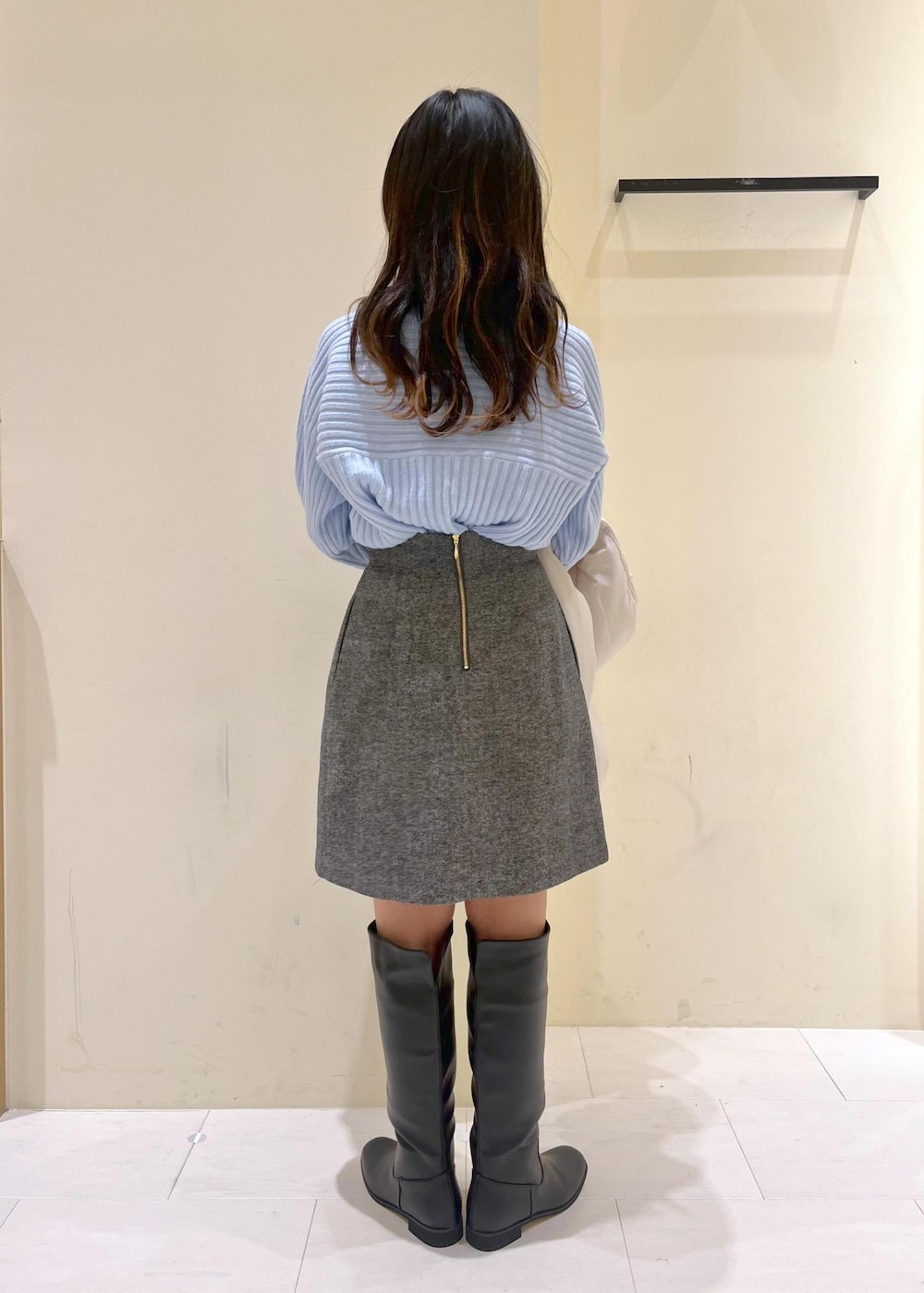 ブラック系のブーツ、ブラウン系のショルダーバッグ、ブルー系のニット/セーターを着用したレディースの冬コーディネートの3枚目の写真