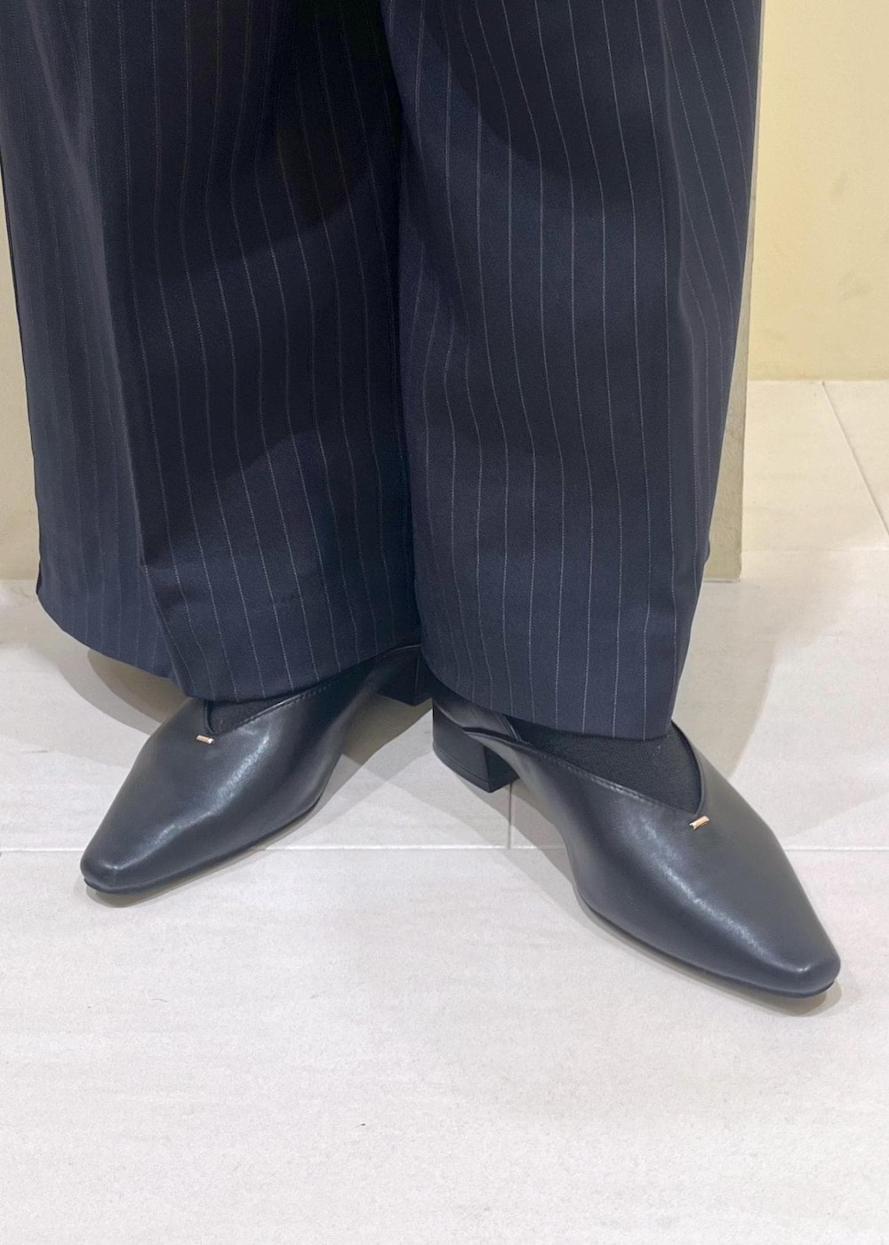 レッド系のショルダーバッグ、ブルー系のその他パンツ、ブラック系のTシャツ/カットソーを着用したレディースの秋コーディネートの10枚目の写真