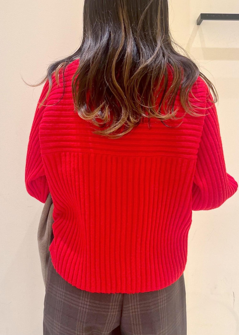 ブラック系のショルダーバッグ、レッド系のニット/セーター、ブラウン系のピーコートを着用したレディースの冬コーディネートの5枚目の写真