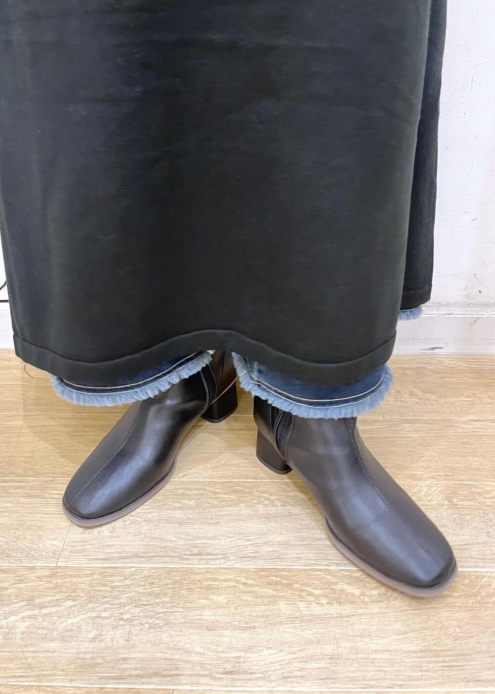 ブルー系のデニムスカート、ブラック系のブーツ、ブラック系のワンピースを着用したレディースの冬コーディネートの10枚目の写真