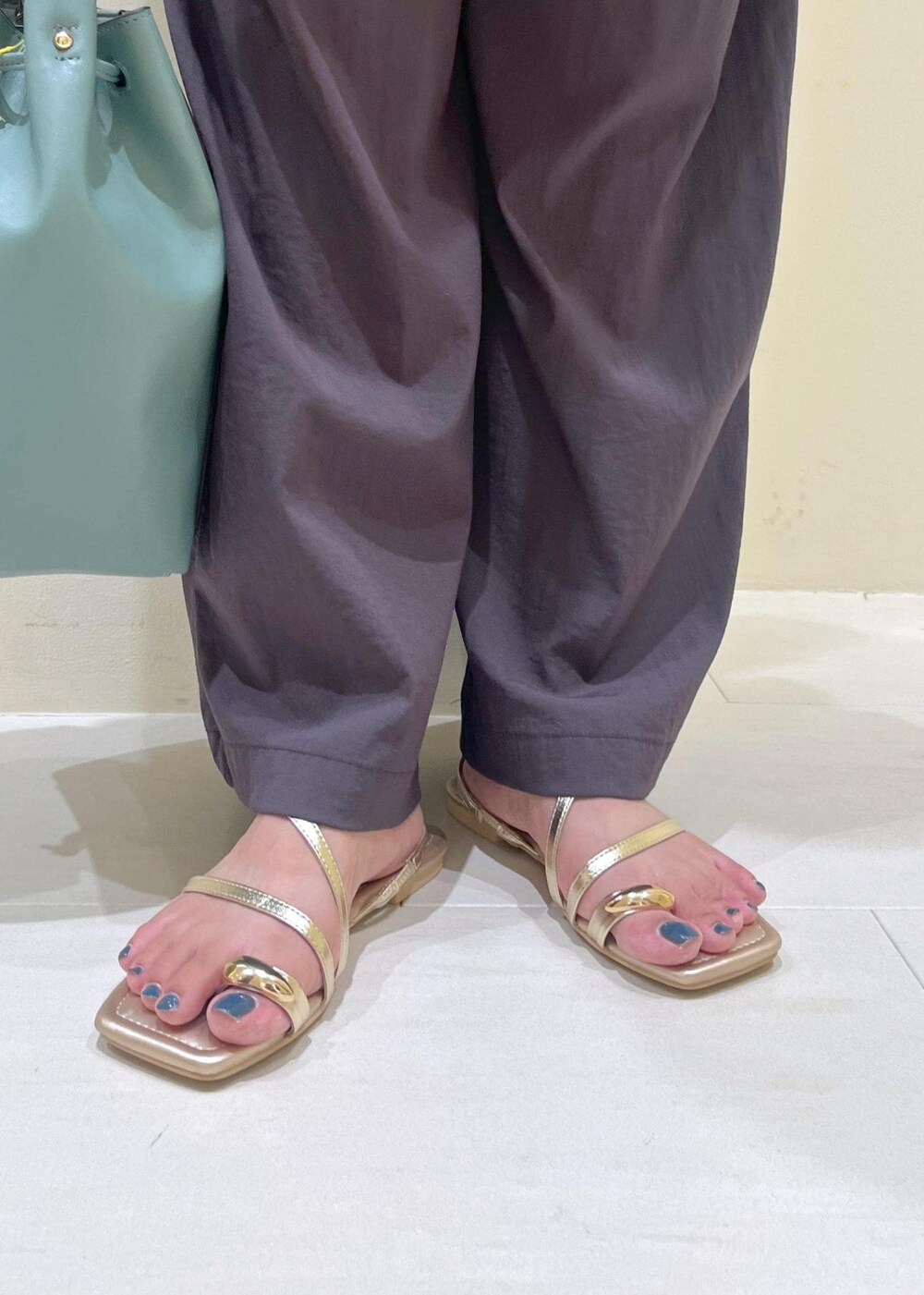 ブルー系のショルダーバッグ、グレー系のその他パンツ、ゴールド系のサンダルを着用したレディースの夏コーディネートの10枚目の写真