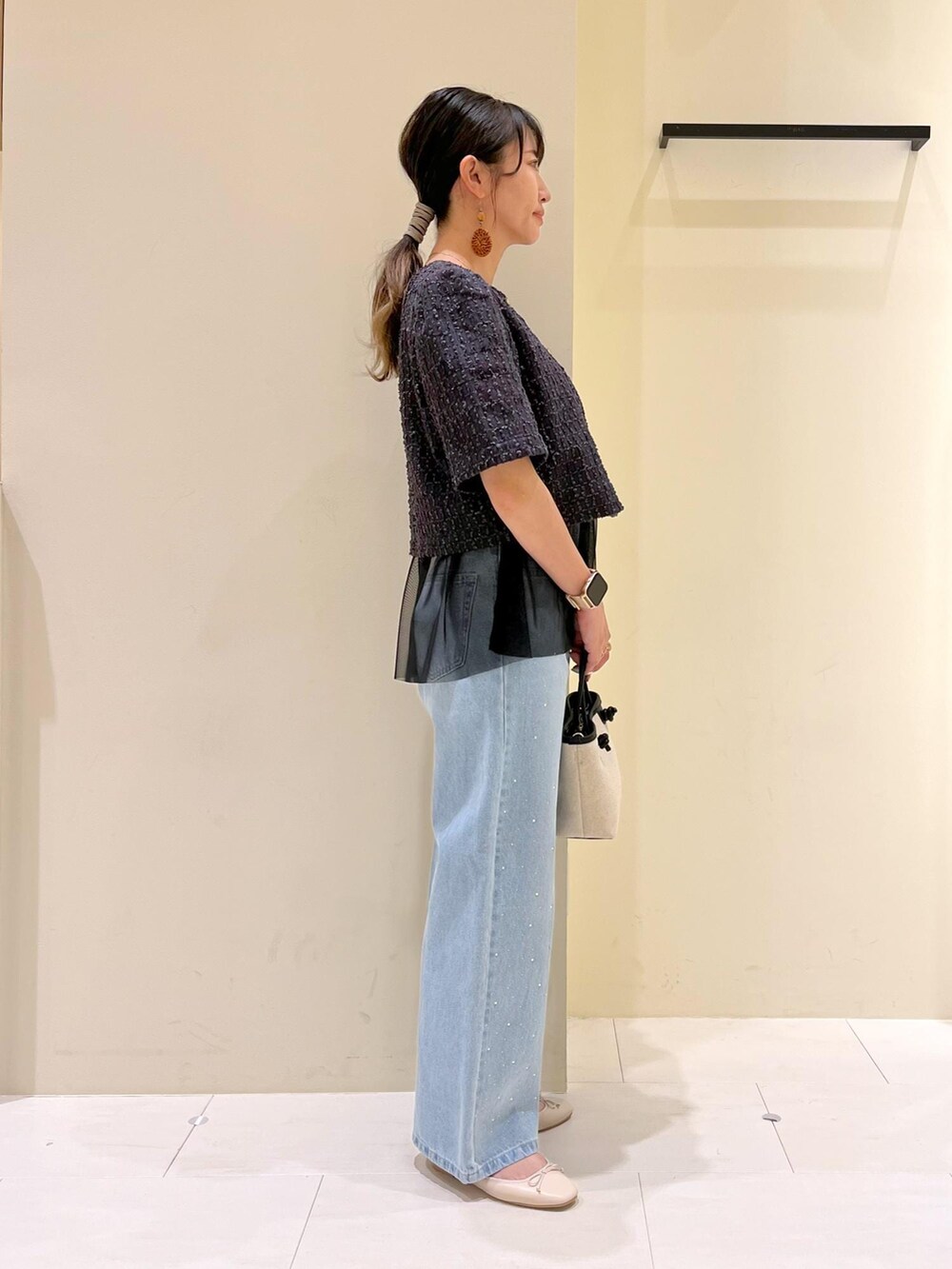 ブルー系のデニムパンツ、ホワイト系のバレエシューズ、グレー系のノーカラージャケットを着用したレディースの春コーディネートの3枚目の写真