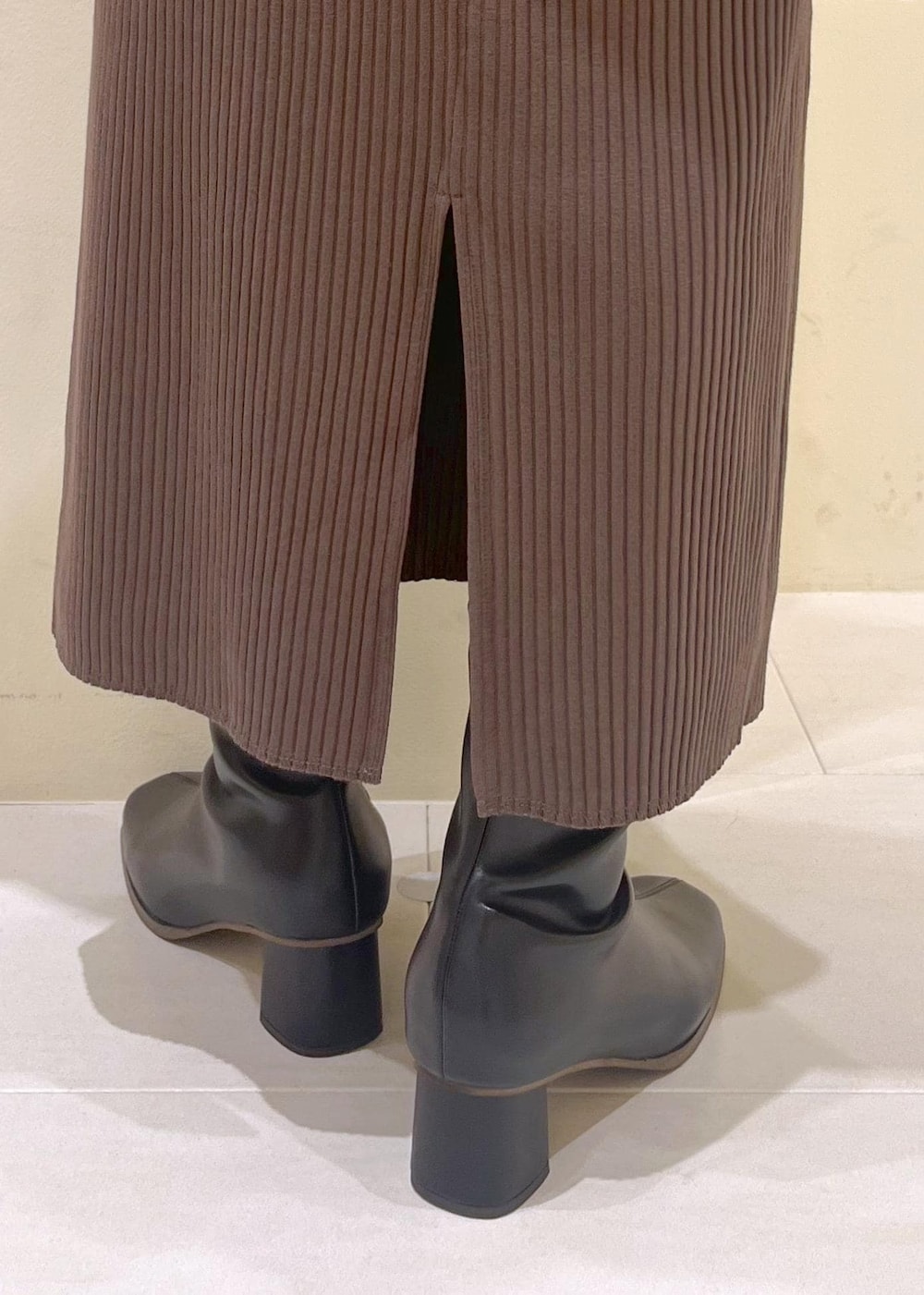 ベージュ系のシャツ/ブラウス、ブラック系のブーツ、グリーン系のスカートを着用したレディースの秋コーディネートの7枚目の写真