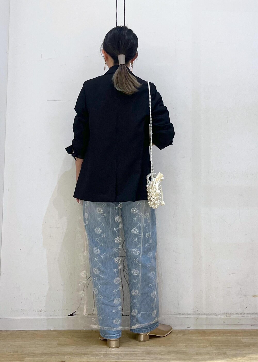 ホワイト系のスカート、ブラック系のニット/セーター、ブラック系のテーラードジャケットを着用したレディースの秋コーディネートの6枚目の写真