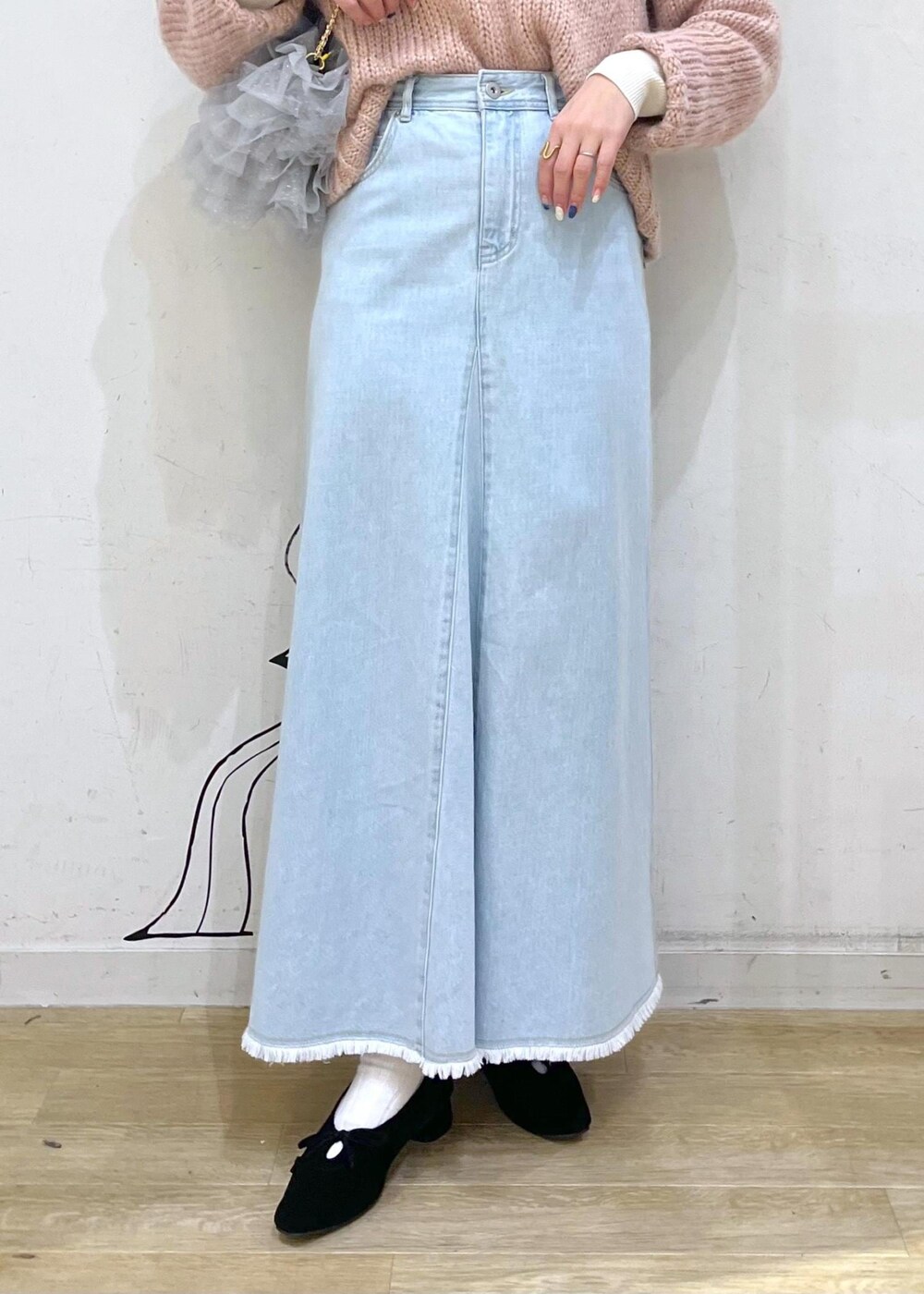 ホワイト系のニット/セーター、ブラック系のパンプス、ブルー系のデニムスカートを着用したレディースの冬コーディネートの7枚目の写真