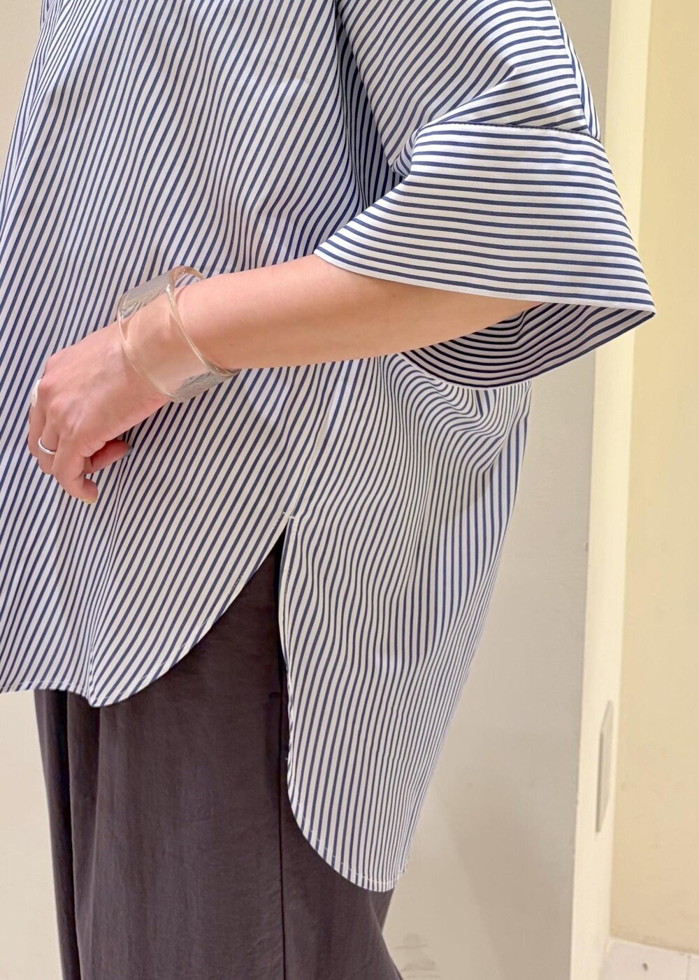 ブルー系のシャツ/ブラウス、ブラック系のニット/セーター、グレー系のその他パンツを着用したレディースの春コーディネートの6枚目の写真