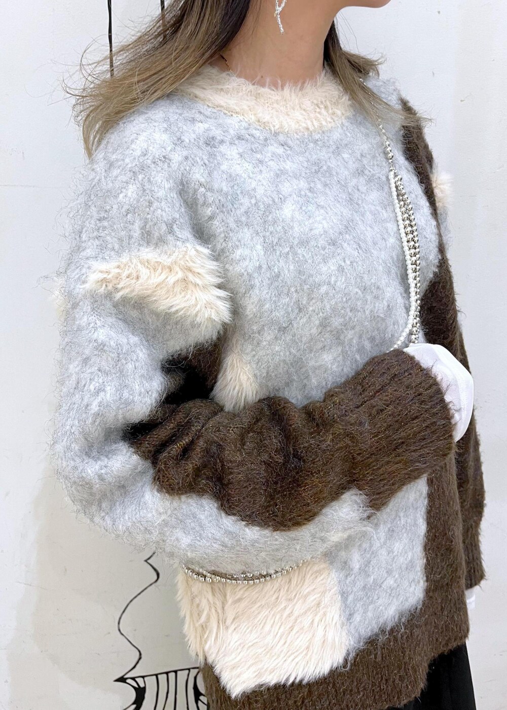 ブラック系のスカート、ブラック系のブーツ、ブラウン系のニット/セーターを着用したレディースの秋コーディネートの6枚目の写真