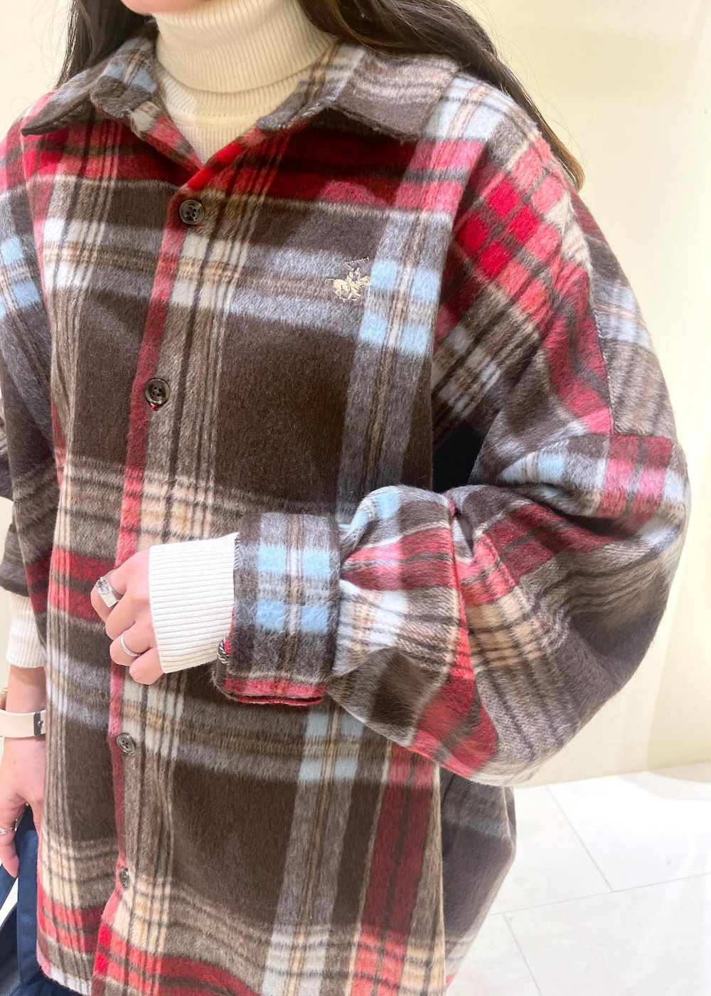 ブラウン系のシャツ/ブラウス、ホワイト系のニット/セーター、グレー系のスラックスを着用したレディースの冬コーディネートの6枚目の写真