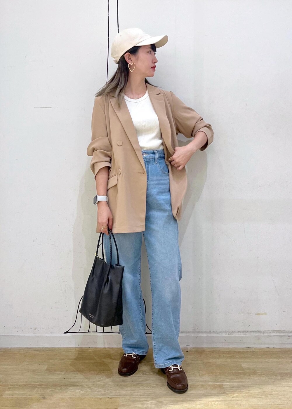 ブラウン系のローファー、ブラック系のトートバッグ、ブルー系のデニムパンツを着用したレディースの秋コーディネートの2枚目の写真
