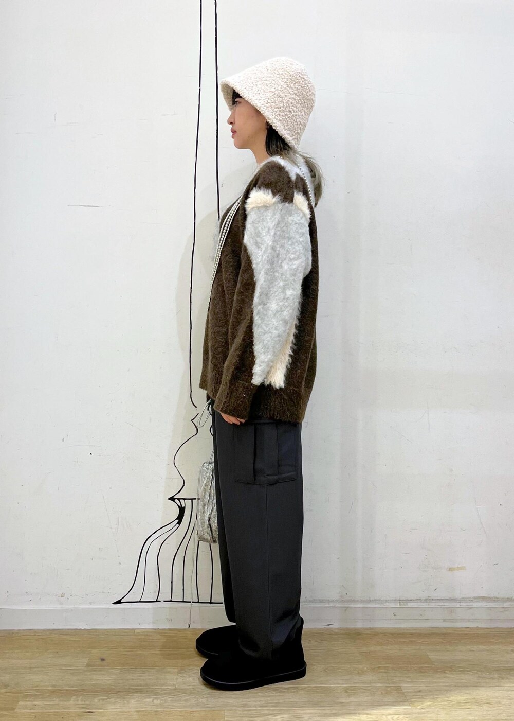 グレー系のカーゴパンツ、シルバー系のショルダーバッグ、ブラウン系のニット/セーターを着用したレディースの秋コーディネートの3枚目の写真