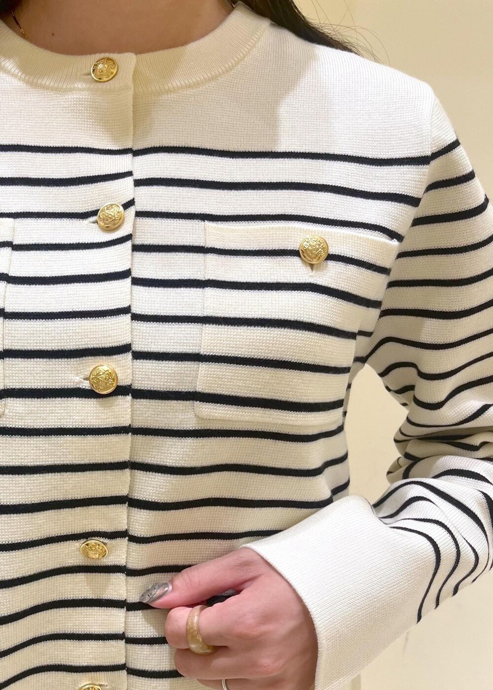 レッド系のショルダーバッグ、ベージュ系のスカート、ホワイト系のカーディガン/ボレロを着用したレディースの秋コーディネートの7枚目の写真