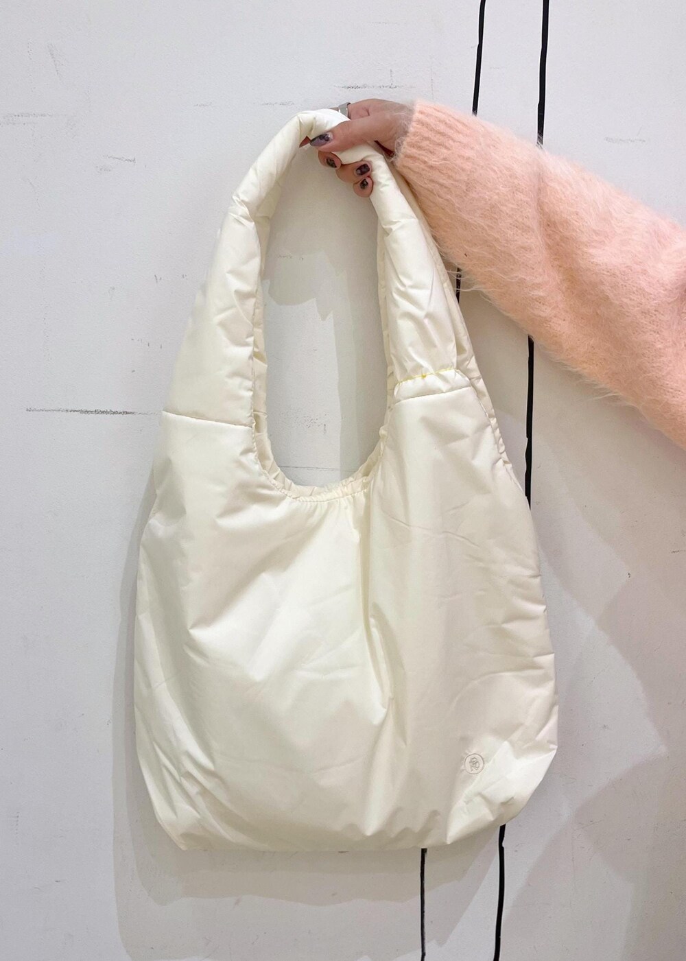 ホワイト系のトートバッグ、ピンク系のニット/セーター、ブラック系のスカートを着用したレディースの冬コーディネートの9枚目の写真