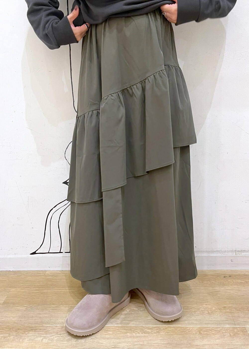 グリーン系のスカート、グレー系のワンピース、ホワイト系のボディバッグ/ウエストポーチを着用したレディースの秋コーディネートの9枚目の写真