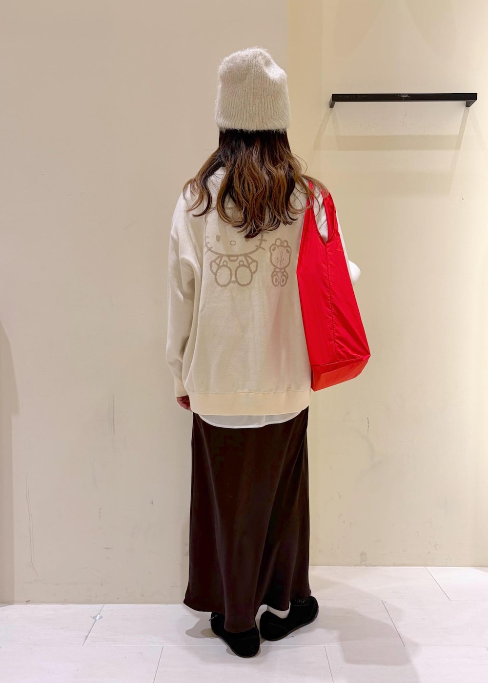 ホワイト系のTシャツ/カットソー、ブラック系のスニーカー、ブラウン系のスカートを着用したレディースの冬コーディネートの3枚目の写真