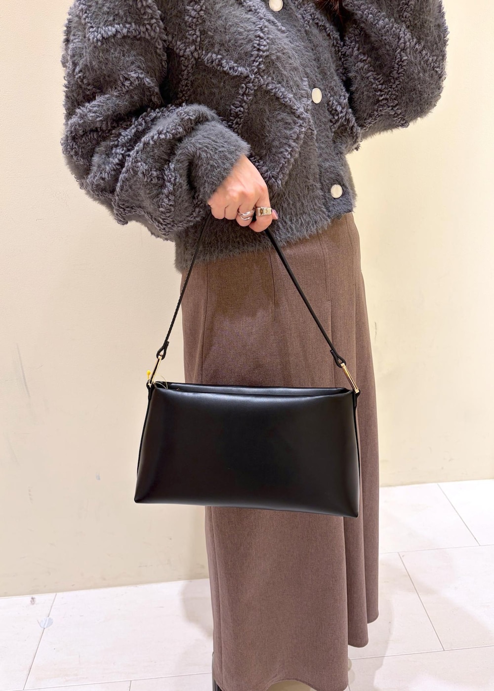 ベージュ系のスカート、グレー系のカーディガン/ボレロ、ホワイト系のTシャツ/カットソーを着用したレディースの冬コーディネートの9枚目の写真