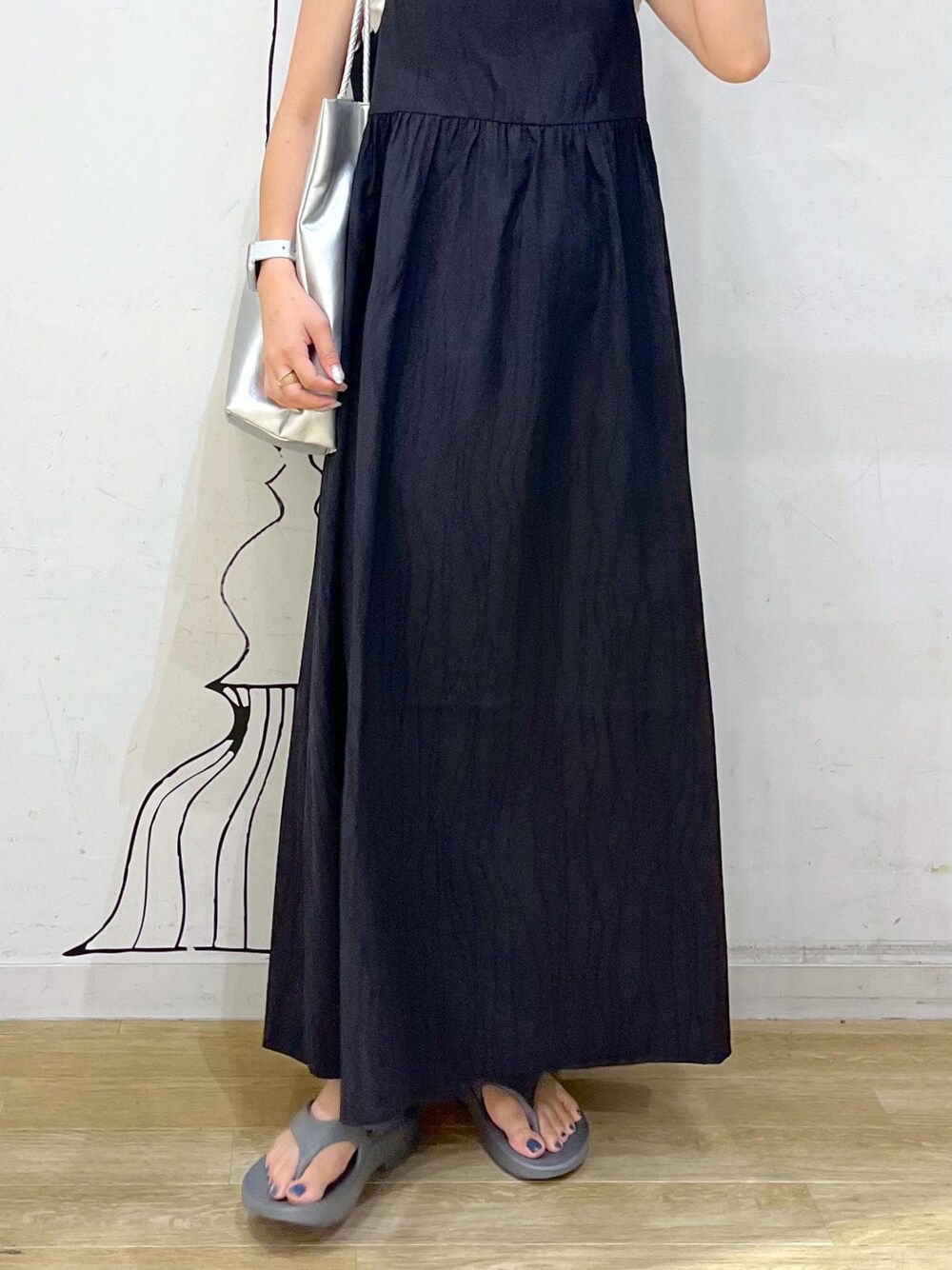 シルバー系のトートバッグ、ベージュ系のタンクトップ、ブラック系のワンピースを着用したレディースの夏コーディネートの8枚目の写真