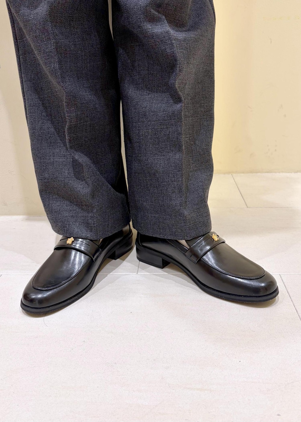 ブラック系のショルダーバッグ、ホワイト系のニット/セーター、グレー系のスラックスを着用したレディースの冬コーディネートの10枚目の写真