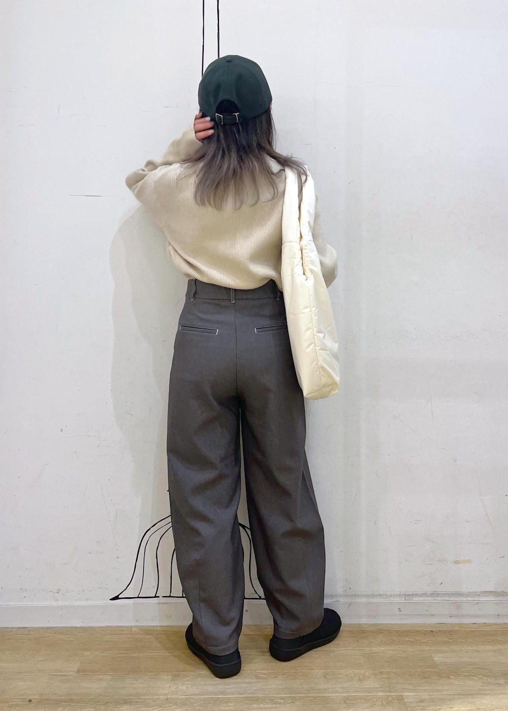 ベージュ系のニット/セーター、ホワイト系のトートバッグ、ブラック系のスリッポンを着用したレディースの冬コーディネートの3枚目の写真