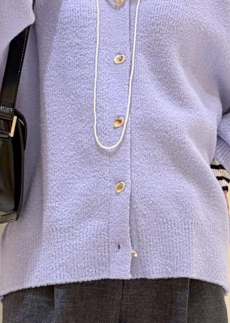 ブラック系のショルダーバッグ、ホワイト系のニット/セーター、グレー系のスラックスを着用したレディースの冬コーディネートの7枚目の写真