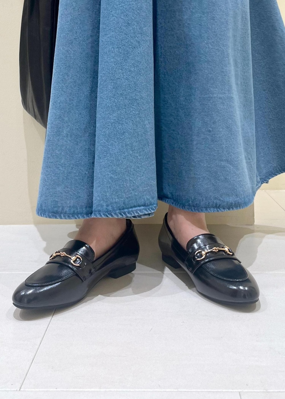 ブラック系のトートバッグ、ブラウン系のシャツ/ブラウス、ブルー系のスカートを着用したレディースの秋コーディネートの9枚目の写真