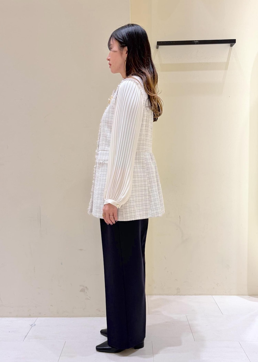 ブラック系のショルダーバッグ、ブルー系のその他パンツ、グレー系のベストを着用したレディースの冬コーディネートの2枚目の写真