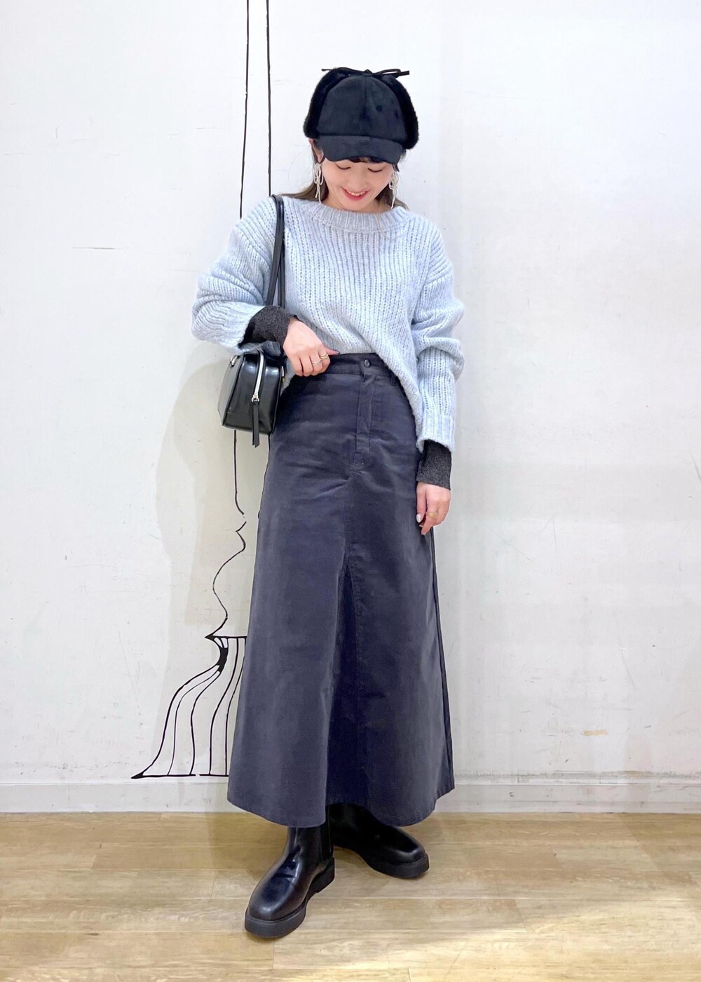 ブラック系のニット/セーター、ブラック系のブーツ、ブラック系のボストンバッグを着用したレディースの冬コーディネートの2枚目の写真