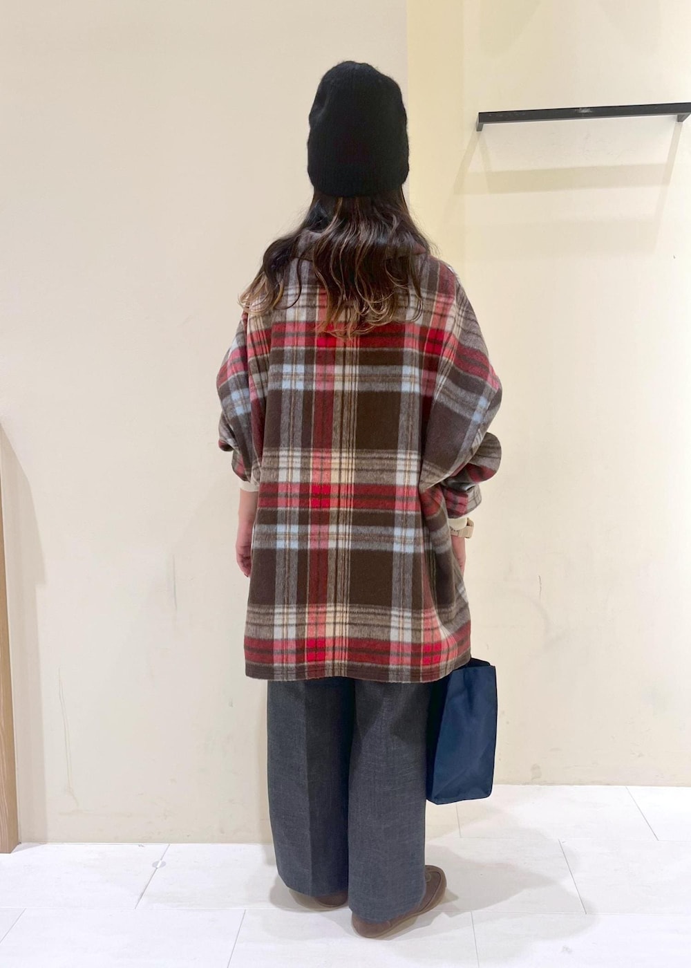 ブラウン系のシャツ/ブラウス、ホワイト系のニット/セーター、グレー系のスラックスを着用したレディースの冬コーディネートの4枚目の写真