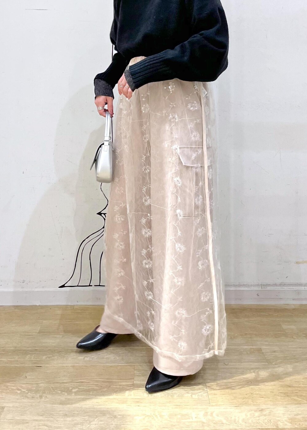 ブラック系のニット/セーター、ホワイト系のスカート、ブラック系のパンプスを着用したレディースの冬コーディネートの8枚目の写真