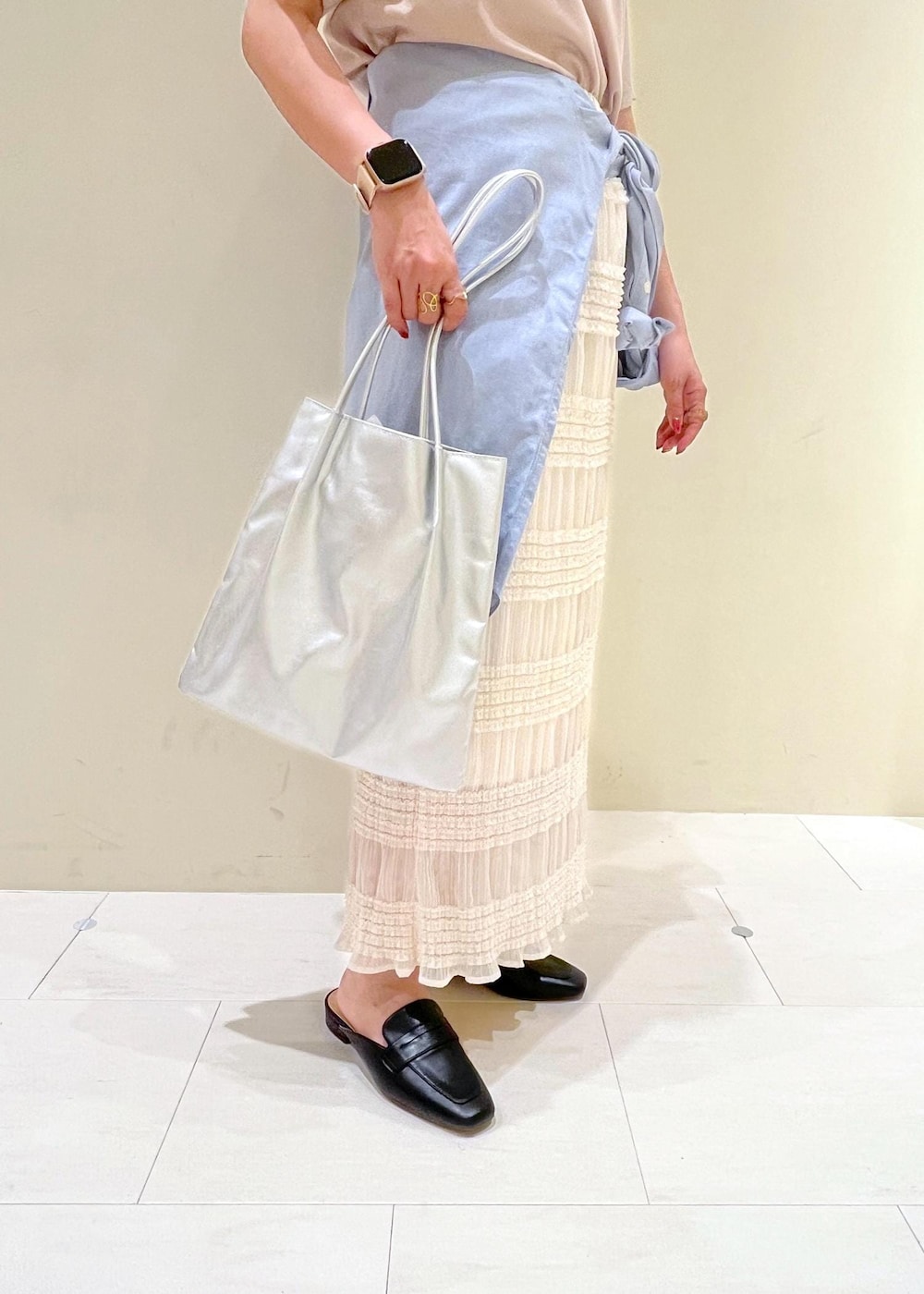 シルバー系のトートバッグ、ブラック系のローファー、ベージュ系のTシャツ/カットソーを着用したレディースの春コーディネートの8枚目の写真