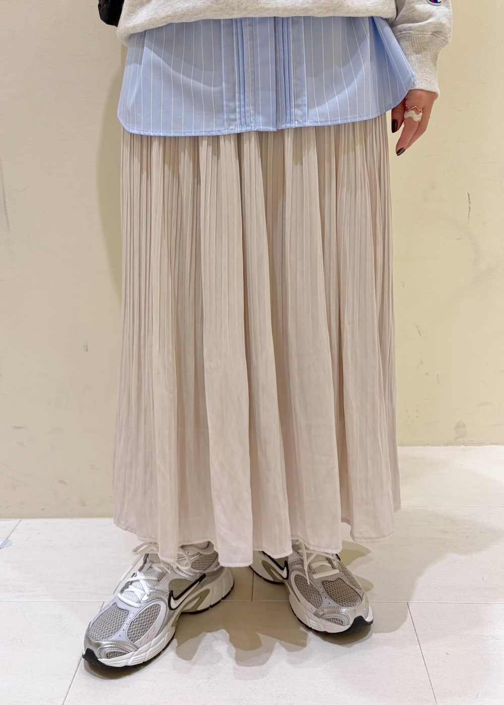 ホワイト系のスウェット、ブルー系のシャツ/ブラウス、ベージュ系のスカートを着用したレディースの冬コーディネートの8枚目の写真