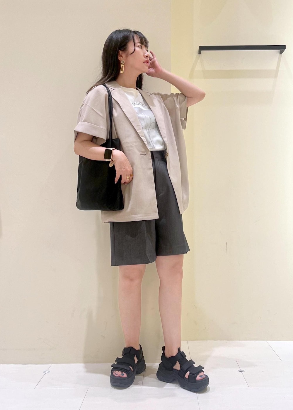 ブラック系のトートバッグ、グレー系のその他パンツ、ベージュ系のテーラードジャケットを着用したレディースの夏コーディネートの2枚目の写真