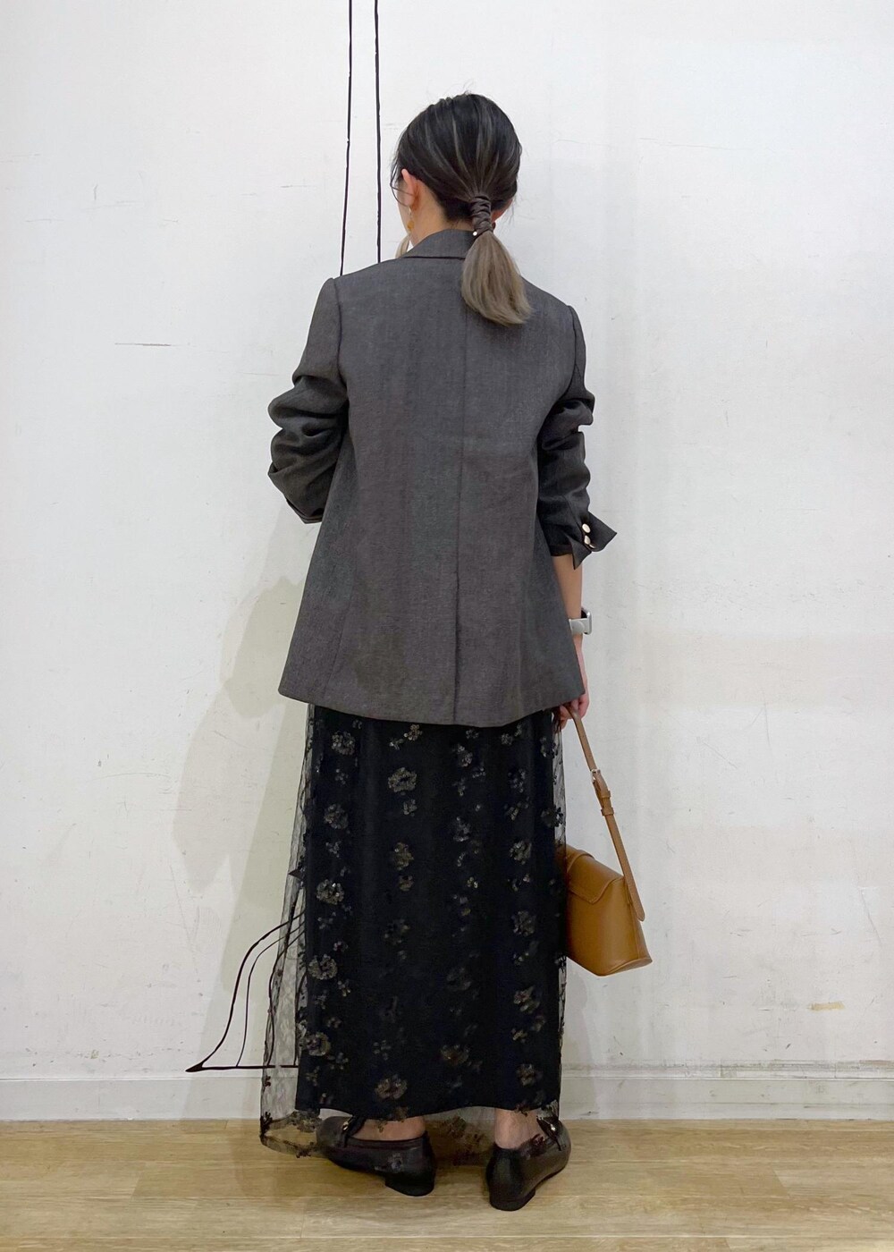 ブラック系のスカート、ベージュ系のTシャツ/カットソー、ブラウン系のテーラードジャケットを着用したレディースの秋コーディネートの5枚目の写真