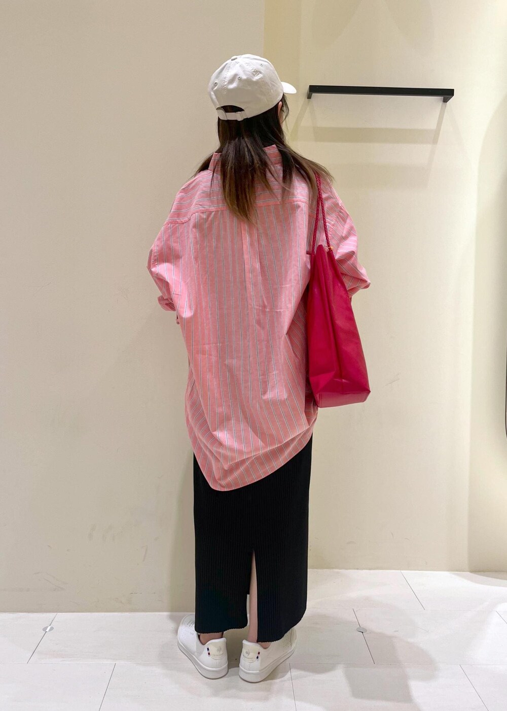 レッド系のトートバッグ、ブラック系のスカート、レッド系のシャツ/ブラウスを着用したレディースの春コーディネートの3枚目の写真