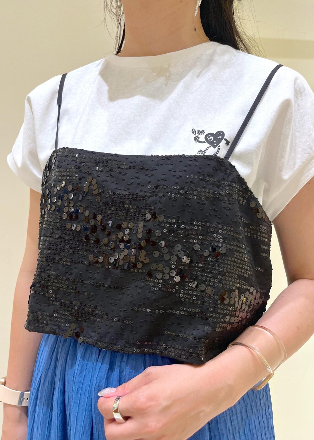 ブラック系のTシャツ/カットソー、ホワイト系のサンダル、ベージュ系のバックパック/リュックを着用したレディースの夏コーディネートの4枚目の写真