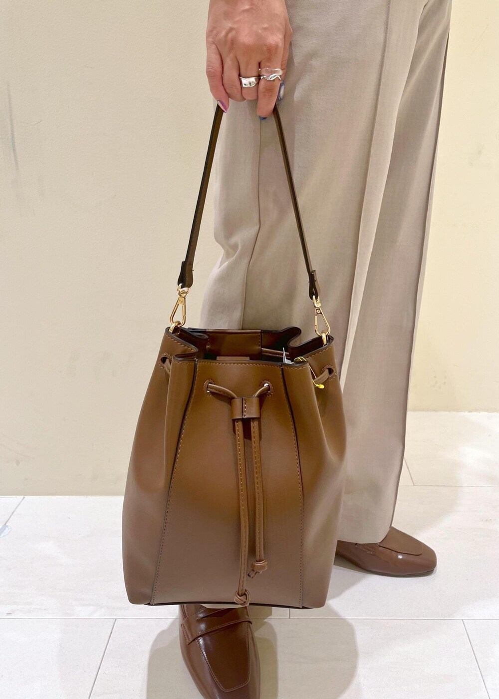 イエロー系のローファー、ベージュ系のその他パンツ、ブラウン系のショルダーバッグを着用したレディースの夏コーディネートの8枚目の写真