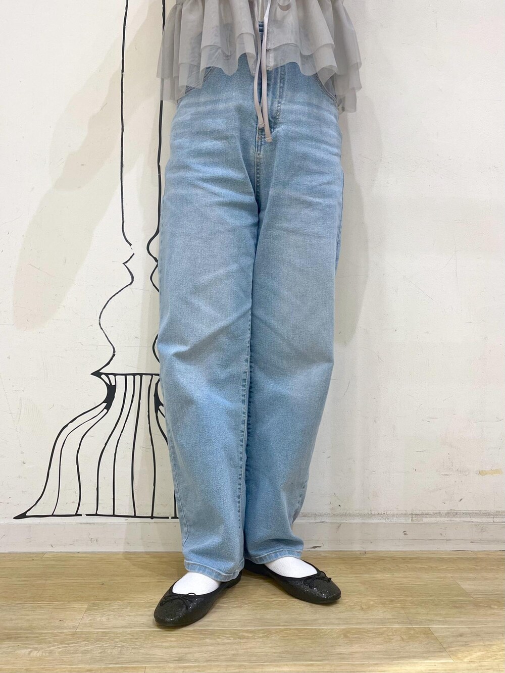 ブルー系のデニムパンツ、レッド系のトートバッグ、ブラック系のその他アウターを着用したレディースの冬コーディネートの7枚目の写真