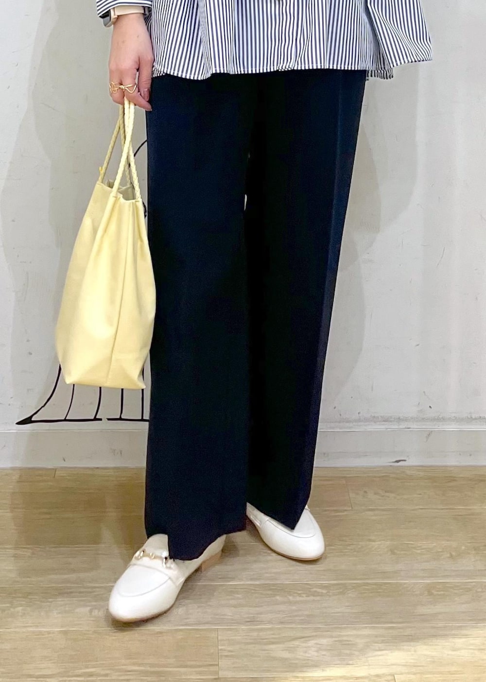 ホワイト系のベスト、ブルー系のその他パンツ、イエロー系のトートバッグを着用したレディースの冬コーディネートの8枚目の写真