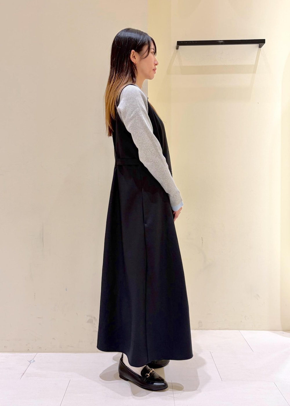 ブラック系のショルダーバッグ、ブラック系のローファー、グレー系のニット/セーターを着用したレディースの冬コーディネートの2枚目の写真