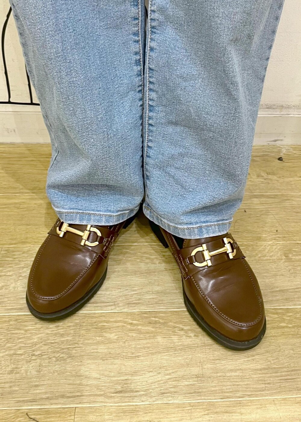 ブラウン系のローファー、ブラック系のトートバッグ、ブルー系のデニムパンツを着用したレディースの秋コーディネートの10枚目の写真