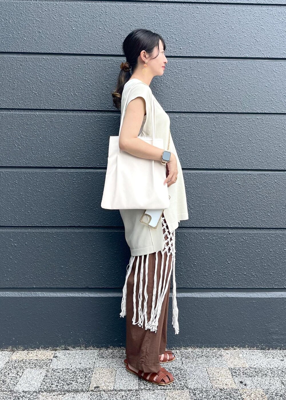 ホワイト系のトートバッグ、ホワイト系のスカート、ブラウン系のその他パンツを着用したレディースの夏コーディネートの3枚目の写真