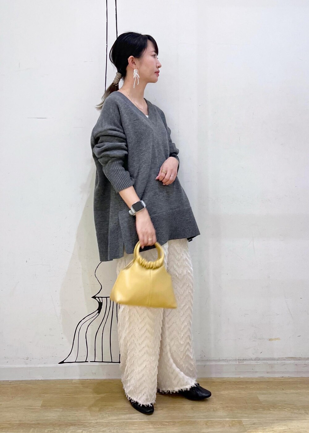 グレー系のタンクトップ、ブラック系のパンプス、イエロー系のショルダーバッグを着用したレディースの夏コーディネートの2枚目の写真