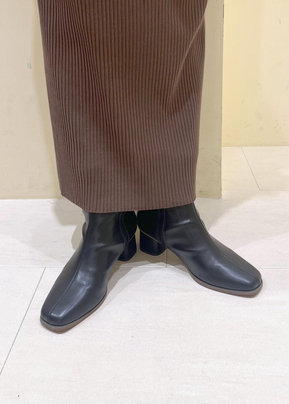 ブルー系のシャツ/ブラウス、ベージュ系のカーディガン/ボレロ、ブラック系のブーツを着用したレディースの秋コーディネートの10枚目の写真