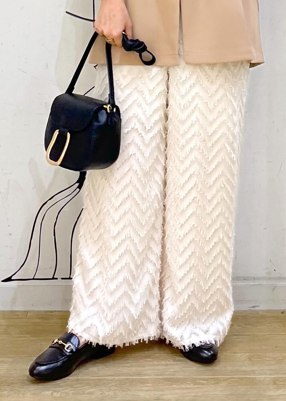 ベージュ系のタンクトップ、ブラック系のショルダーバッグ、ベージュ系のその他パンツを着用したレディースの秋コーディネートの8枚目の写真