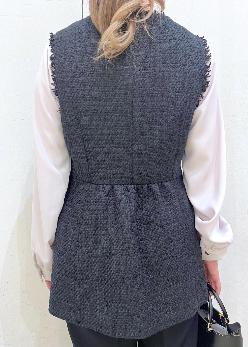 ブラック系のローファー、ブラック系のショルダーバッグ、ブルー系のベストを着用したレディースの冬コーディネートの6枚目の写真