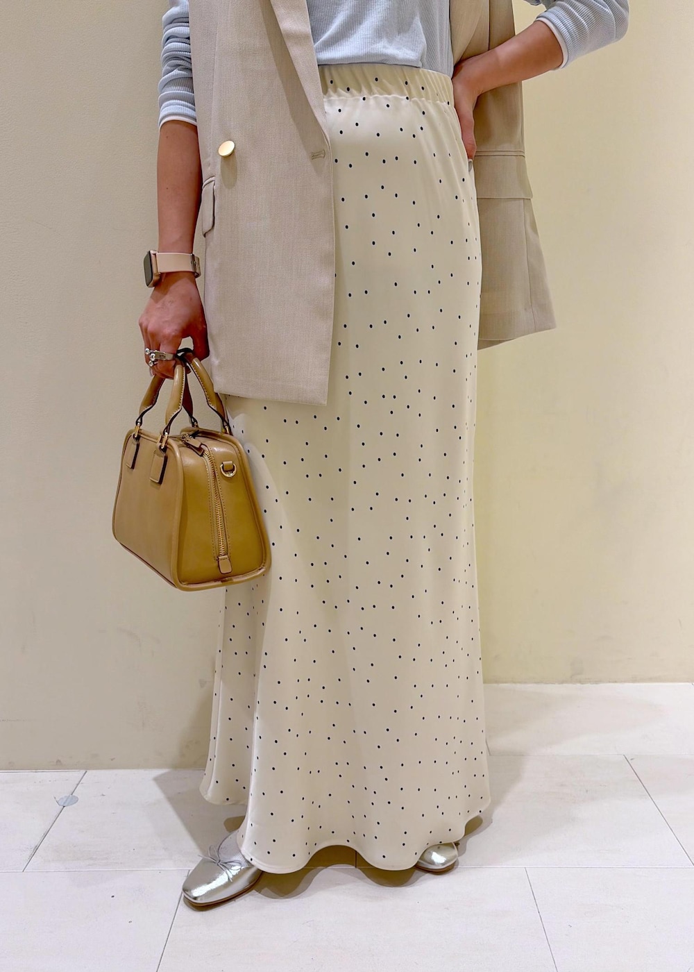 ベージュ系のボストンバッグ、ブルー系のTシャツ/カットソー、ベージュ系のベストを着用したレディースの春コーディネートの7枚目の写真