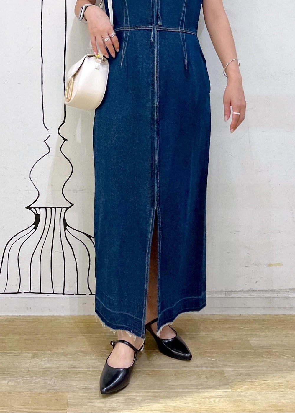 グレー系のタンクトップ、ブラック系のパンプス、ホワイト系のショルダーバッグを着用したレディースの夏コーディネートの7枚目の写真