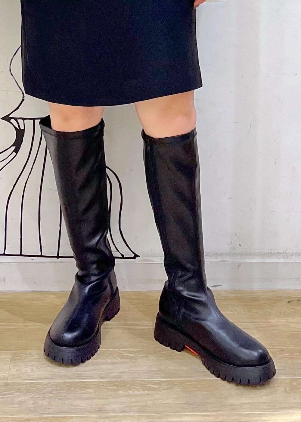 ブラック系のスカート、ブラック系のブーツ、ブラウン系のニット/セーターを着用したレディースの秋コーディネートの9枚目の写真